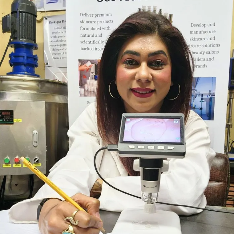 Sharika Regchand, founder of ShaRique Skin, examining skin under a digital microscope