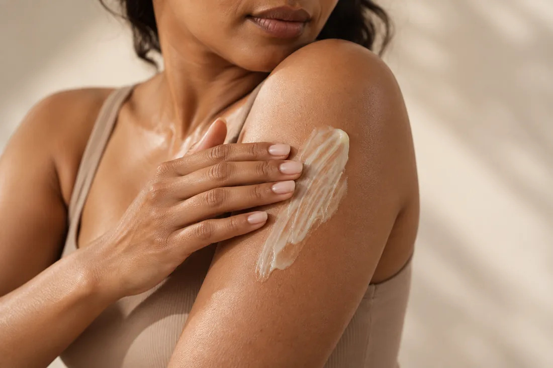 Woman smoothing ShaRique anti-ageing retinol body cream into her upper arm at night